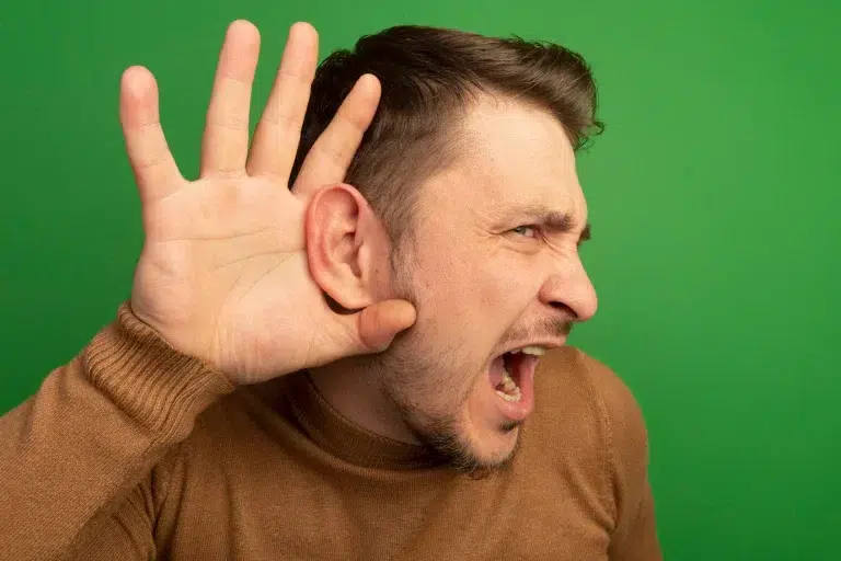 Hombre con perdida auditiva o hipoacusia haciendo gesto de escuchar